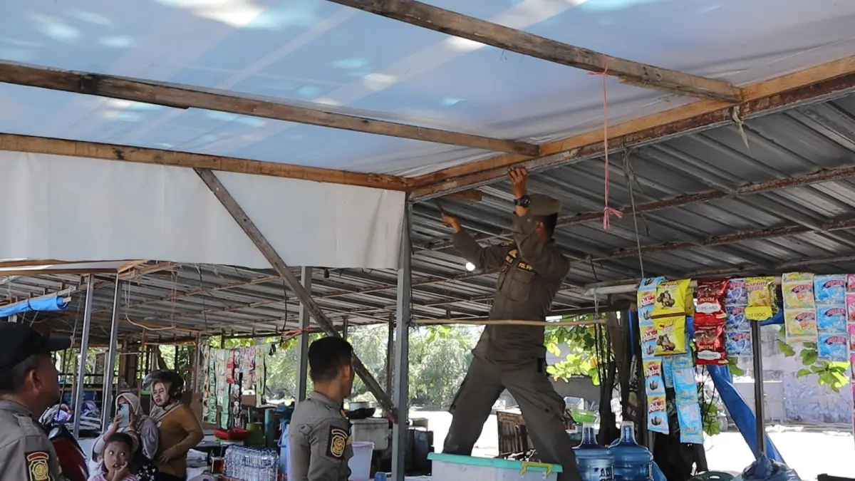 Tim gabungan Kota Padang menertibkan dan membongkar bangunan tambahan milik pedagang di kawasan Pusat Kuliner Pantai Padang, Selasa (23/6/2026). 