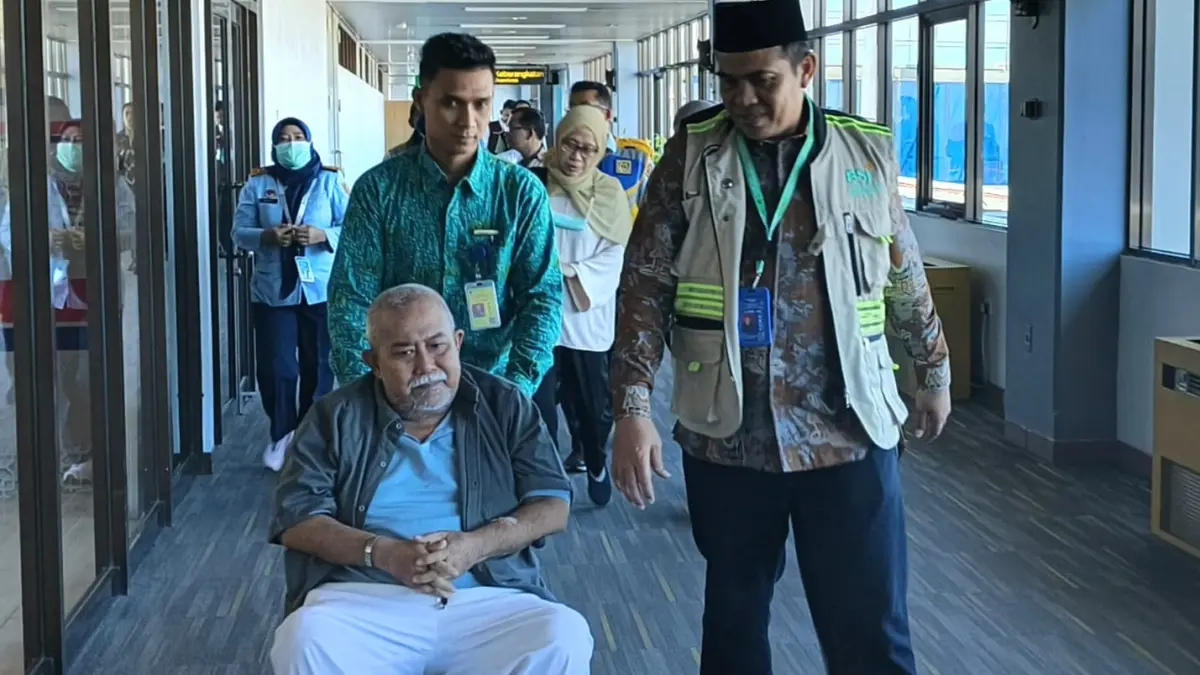Kepala Kanwil Kementerian Haji dan Umrah Sumbar M Rifki menyambut jemaah haji Debarkasi Padang yang tiba di Bandara Internasional Minangkabau setelah menjalani perawatan di Arab Saudi, Selasa (23/6/2026).
