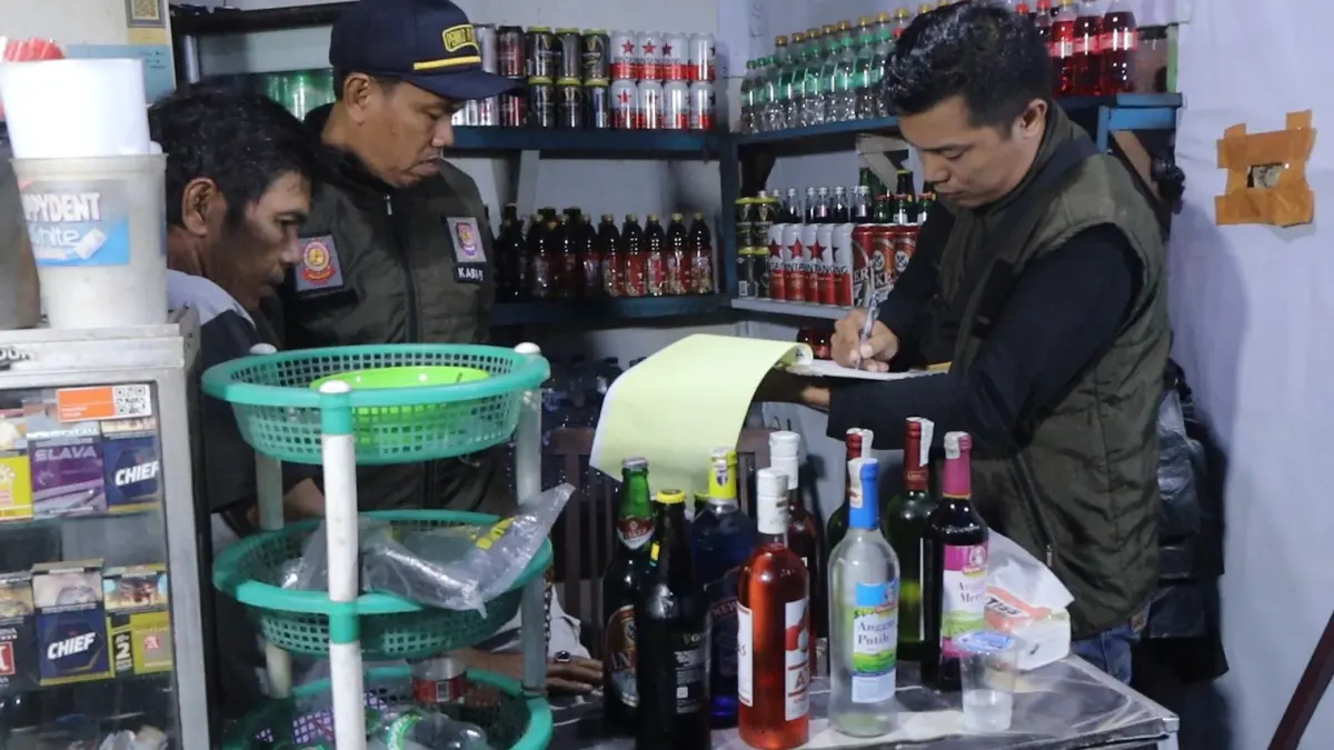 Petugas Satpol PP Kota Padang mengamankan puluhan botol minuman beralkohol saat razia di tiga lokasi, Jumat dini hari (26/6/2026). 