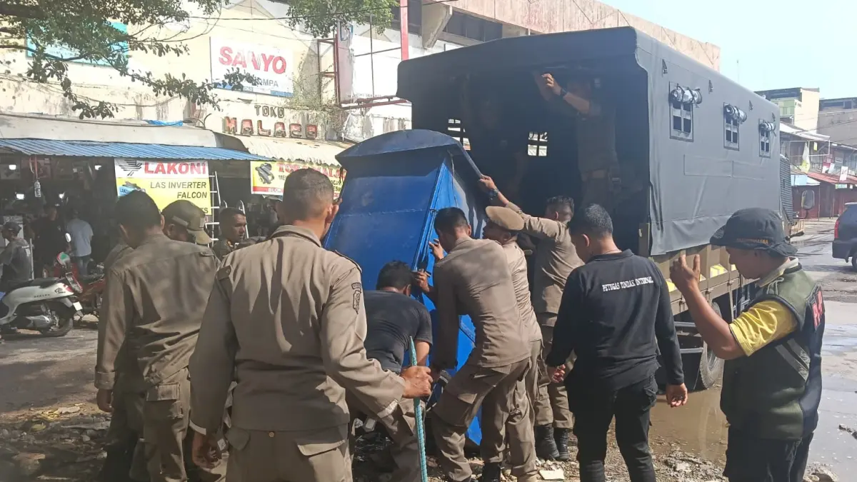 Personel Satpol PP Kota Padang menertibkan lapak pedagang kaki lima (PKL) di kawasan Pasar Raya Barat, Minggu (28/6/2026), guna mendukung kelancaran proyek revitalisasi Pasar Raya Padang. 