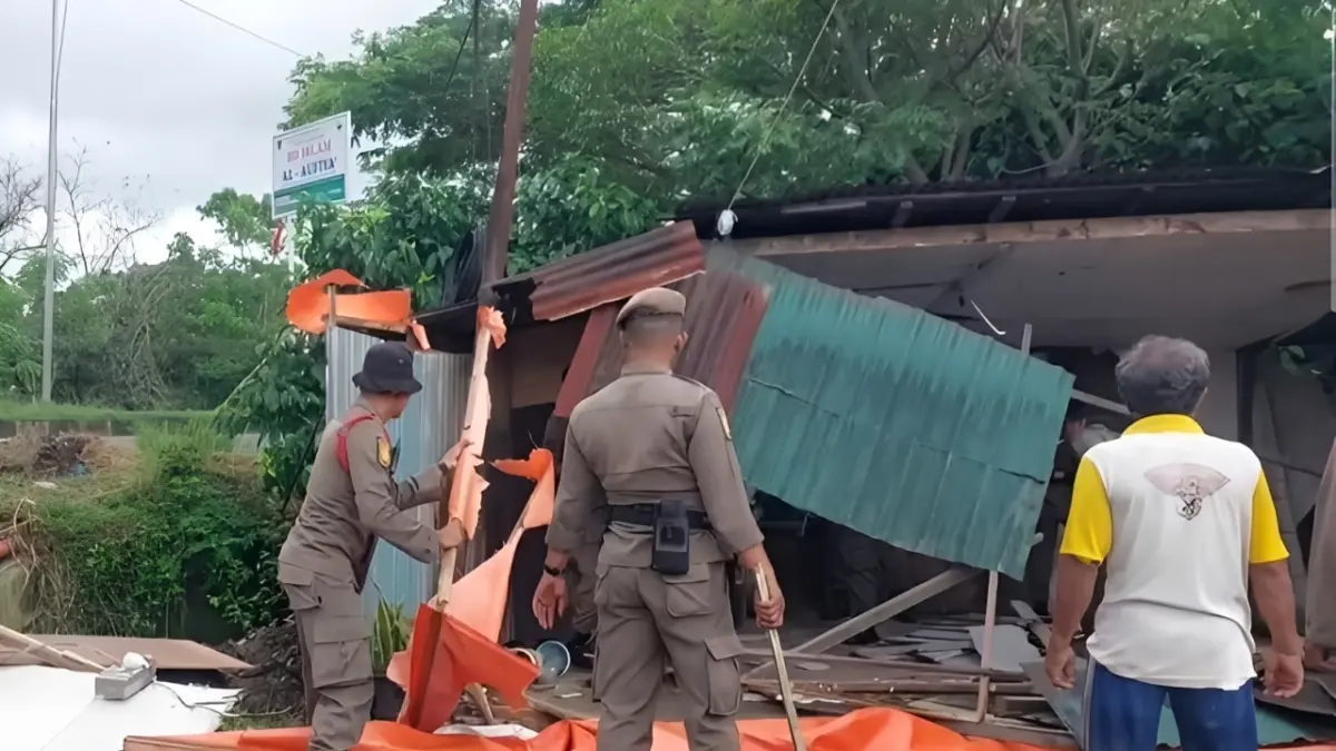 Petugas Satpol PP Kota Padang membongkar bangunan liar yang berdiri di atas saluran drainase di perbatasan Kelurahan Koto Panjang Ikur Koto dan Kelurahan Aiepacah, Kecamatan Kototangah, Senin (29/6/2026). 