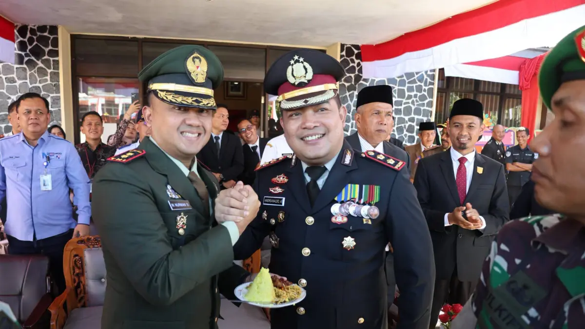Suasana penuh keakraban mewarnai peringatan Hari Bhayangkara ke-80 saat Dandim 0308/Pariaman Letkol Inf M Nurman Setiaji (kiri) dan Kapolres Pariaman AKBP Andreanaldo Ademi melakukan salam komando usai prosesi potong tumpeng di Mapolres Pariaman, Rabu (1/7/2026). (MC Kominfo Kota Pariaman)