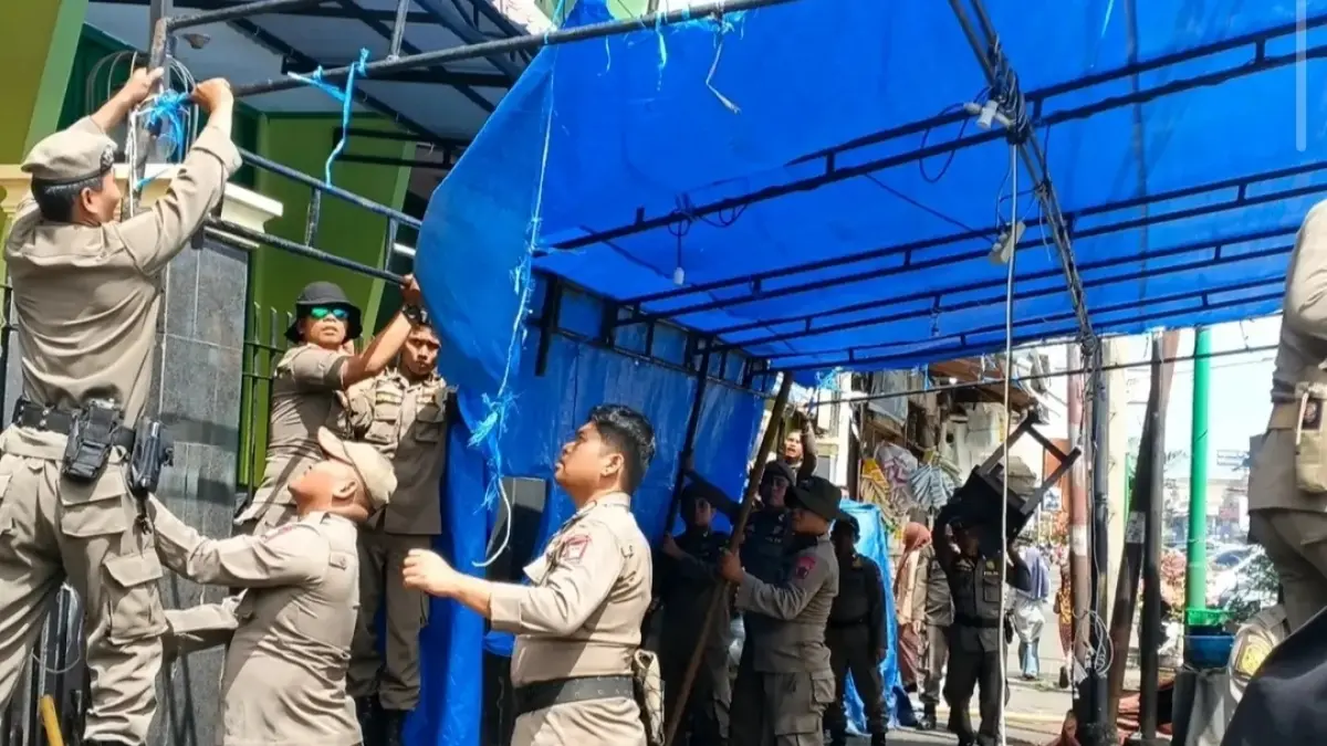 Personel Satpol PP Kota Padang menertibkan pedagang kaki lima yang berjualan di badan jalan kawasan Pasar Raya Padang, Kamis (2/7/2026). Penataan dilakukan untuk membuka akses jalur proyek dan mendukung percepatan revitalisasi Pasar Raya. 