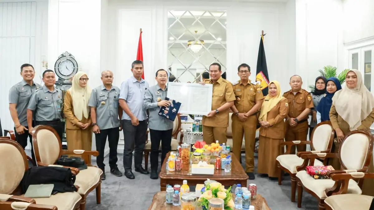Kepala Kanwil Kementerian Hukum Sumatera Barat, Alpius Sarumaha, menyerahkan sertifikat merek Batik Sampan kepada Wali Kota Pariaman, Yota Balad, di Ruang Kerja Wali Kota Pariaman, Selasa (7/7). (DOK PEMKO PARIAMAN)