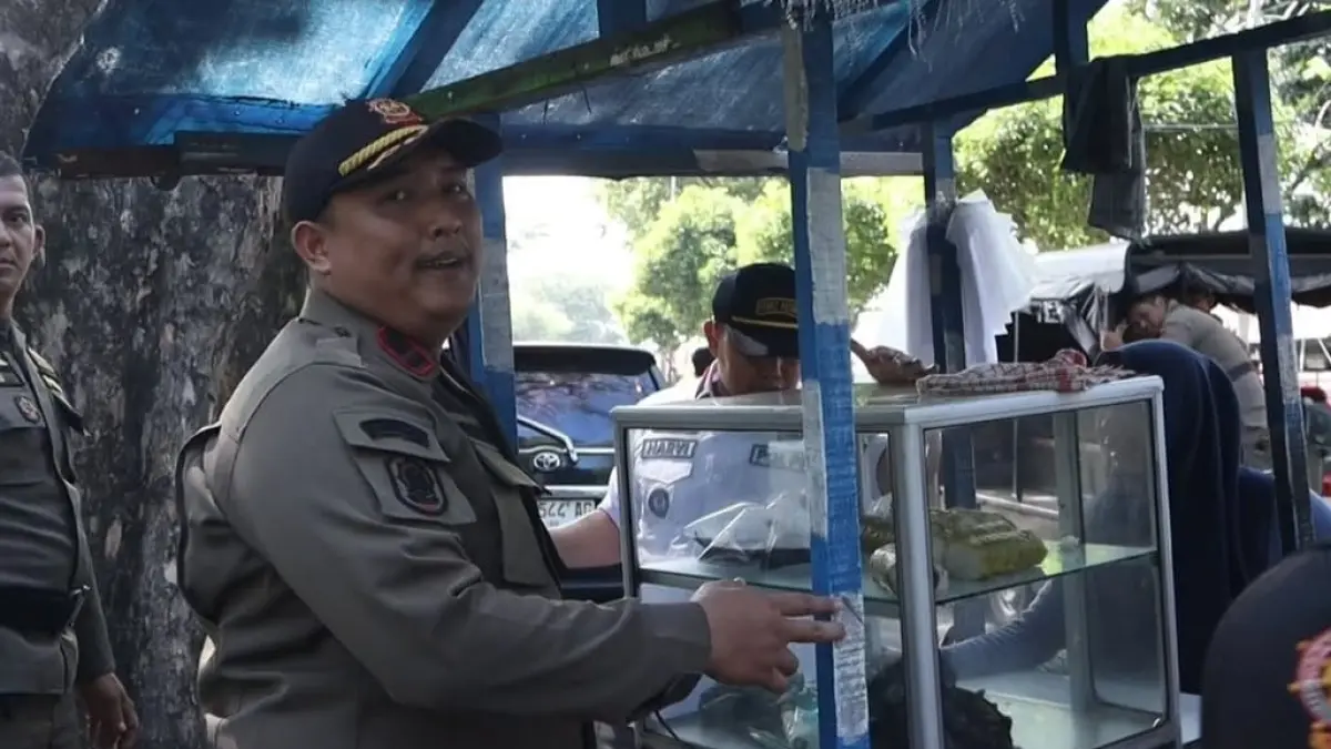Personel Satpol PP Kota Padang mengamankan perlengkapan milik pedagang kaki lima saat penertiban di lima ruas jalan protokol, Rabu (8/7/2026). 