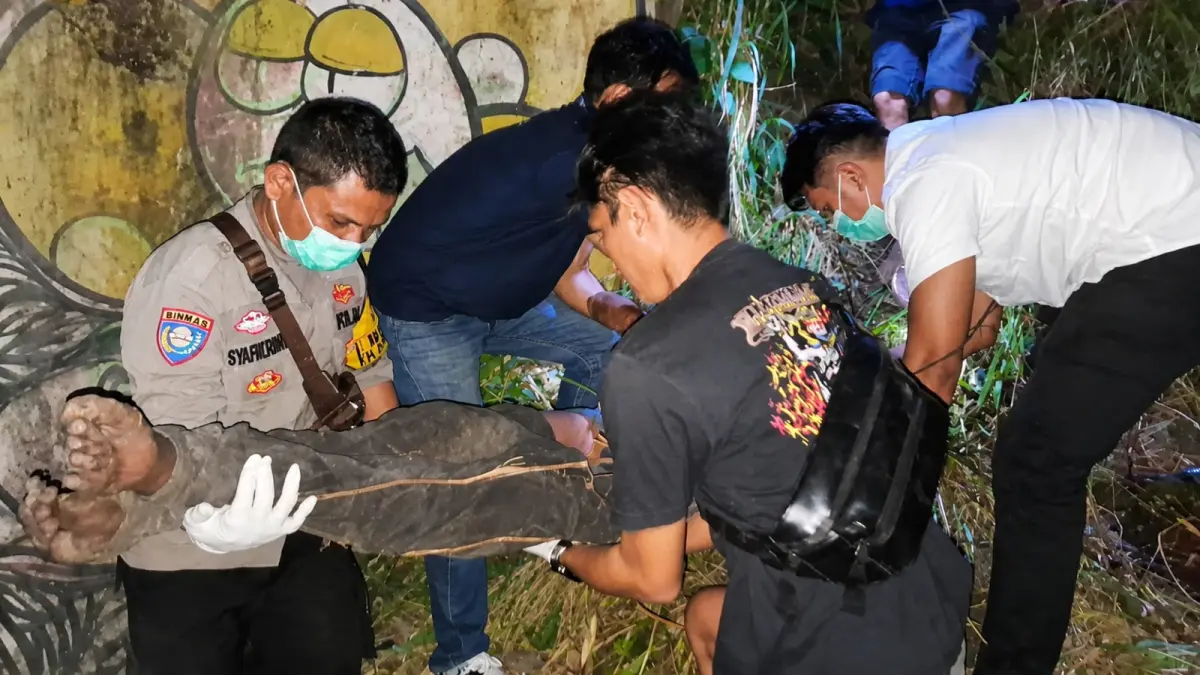 Petugas kepolisian mengevakuasi jasad pria tanpa identitas yang ditemukan di bawah jembatan rel kereta api di Korong Duku, Nagari Kasang, Kecamatan Batang Anai, Kabupaten Padangpariaman, Rabu (8/7/2026).
