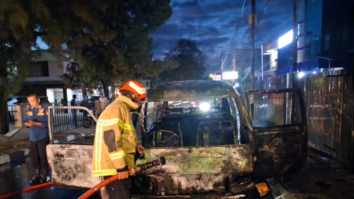 Petugas Dinas Pemadam Kebakaran dan Penyelamatan (DPKP) Kota Bukittinggi melakukan proses pendinginan pada satu unit mobil Colt T120 yang hangus terbakar di Jalan Nawawi, Kelurahan Tarok Dipo, Bukittinggi, Kamis (9/7/2026). (Foto: DPKP Kota Bukittinggi)
