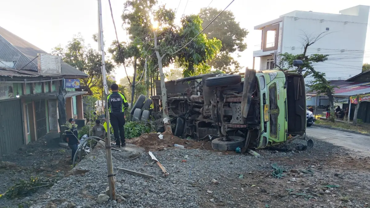 Kondisi truk yang terbalik di Jalan Raya Bukittinggi-Payakumbuh, Nagari Sungai Cubadak, Kecamatan Baso, Kabupaten Agam, Jumat (10/7/2026). Material muatan truk tumpah dan mengenai empat rumah warga. (Foto: Satlantas Polresta Bukittinggi)