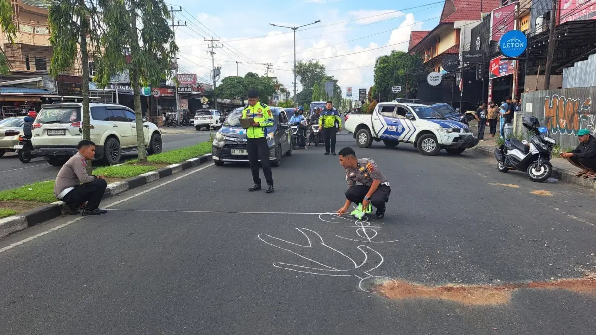 Petugas Satlantas Polres Payakumbuh melakukan olah TKP kecelakaan yang menewaskan seorang ASN setelah ditabrak sepeda motor saat menyeberang di Jalan Soekarno-Hatta, Kelurahan Balai Nan Duo, Kecamatan Payakumbuh Barat, Jumat (10/7). (SY RIDWAN/PADEK)