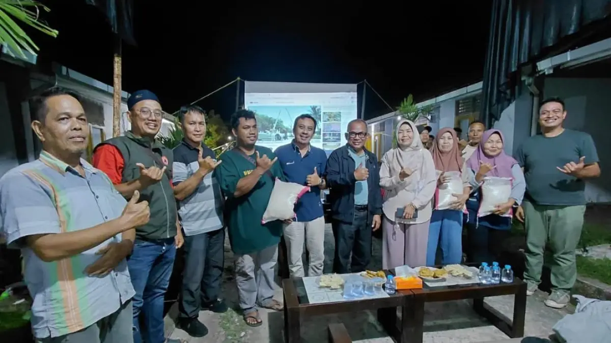 Kepala Dinas Perkim Kota Padang Tri Hadiyanto bersama warga Huntara Lubuk Buaya saat nobar perempat final Piala Dunia 2026 dan penyaluran bantuan beras kepada 109 kepala keluarga.(Foto: Diskominfo)