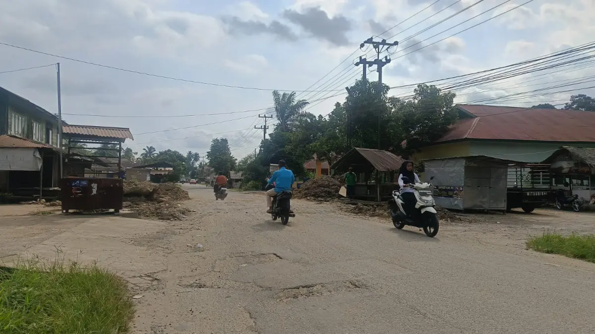 PERBAIKAN BERLANGSUNG: Kendaraan melintasi ruas jalan provinsi di kawasan Balai Salasa, Kecamatan Lubukbasung, Jumat (17/7), saat proses pengerjaan jalan provinsi tersebut dengan box culvert masih berlangsung.(PUTRA/PADEK)