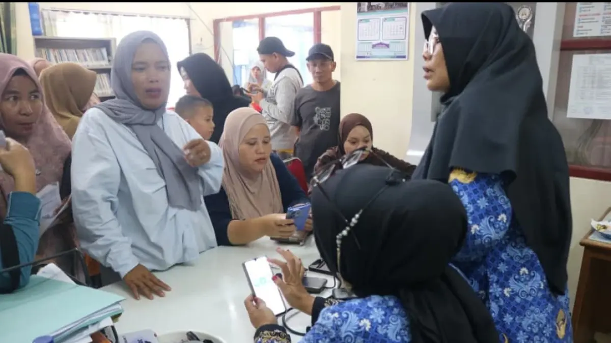 Petugas Kelurahan Air Pacah membantu masyarakat mendaftar di Portal Perlinsos untuk pendataan calon penerima bantuan sosial di Kota Padang.(Foto: Diskominfo)
