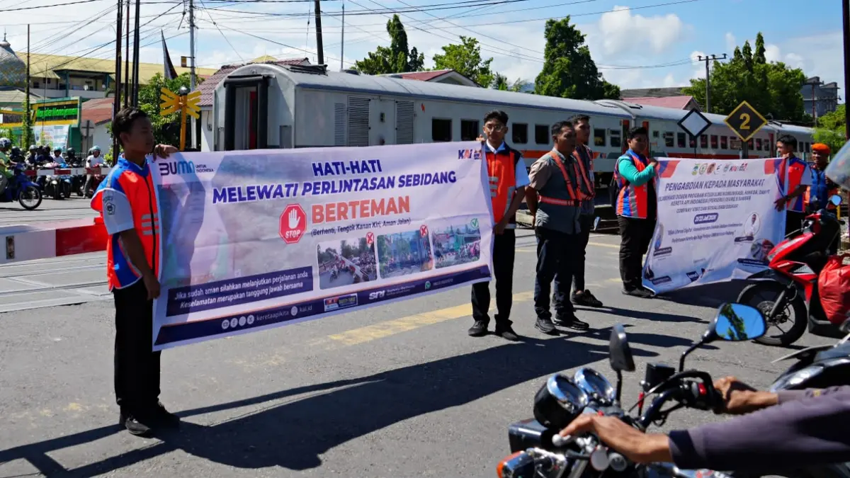 Mahasiswa Universitas Dharma Andalas, siswa SMKN 6 Padang, dan petugas KAI Divre II Sumbar memberikan edukasi kepada pengguna jalan di perlintasan sebidang KM 0+805 Simpang Haru, Padang, Selasa (21/7/2026), sebagai upaya meningkatkan keselamatan perjalanan kereta api dan pengguna jalan.