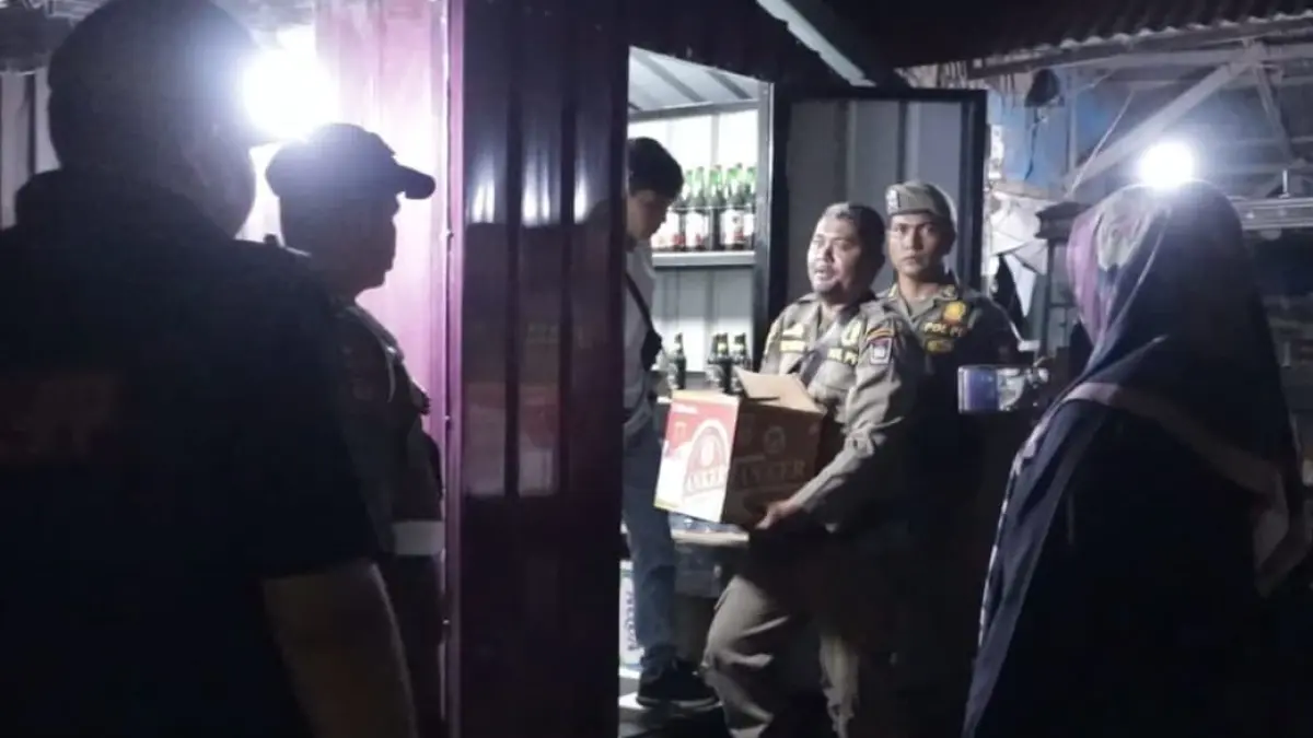Petugas Satpol PP Kota Padang mengamankan barang bukti minuman beralkohol tanpa izin saat patroli penegakan Perda Ketertiban Umum di sebuah warung.(Foto: Diskominfo)