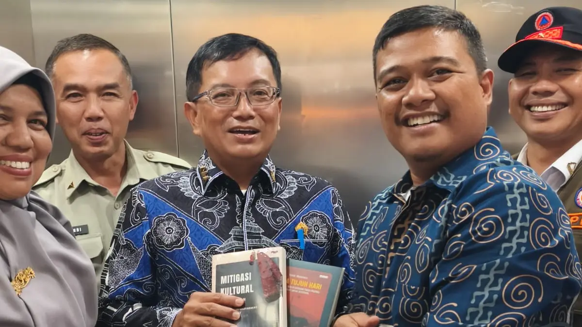 Penulis buku Gempa Tujuh Hari, Yose Hendra menyerahkan buku kepada Sekretaris Utama BNPB Dr Apt Rustian SSi MKes, usai acara bedah buku di Perpustakaan Unand, Rabu (22/7/2026).