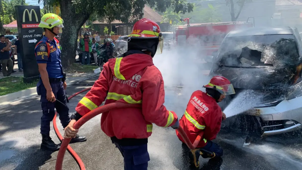 Petugas Dinas Pemadam Kebakaran Kota Padang memadamkan api yang membakar satu unit mobil Honda Freed di kawasan pertokoan Jalan Bandar Damar, Kelurahan Olo, Kecamatan Padang Barat, Kota Padang, Jumat (24/7/2026).