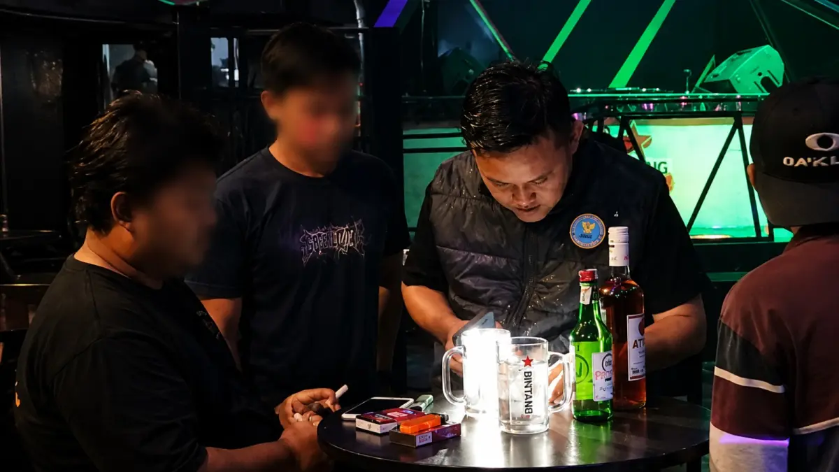 Personel BNN memeriksa identitas pengunjung saat Operasi Yustisi di tempat hiburan malam di kawasan Padang Barat dan Padang Selatan, Minggu dini hari (26/7/2026).