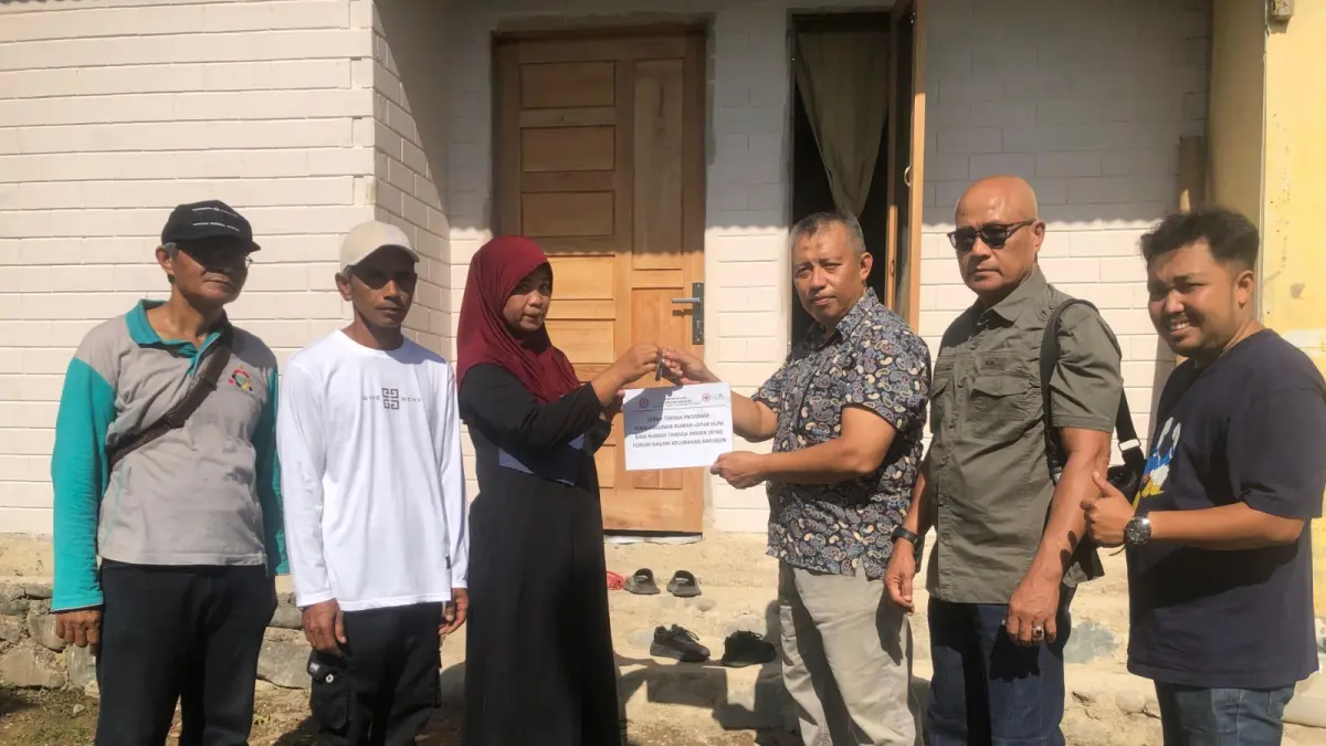 Destimar Irawati bersama keluarga menerima kunci rumah layak huni yang dibangun PT Semen Padang melalui program TJSL berkolaborasi dengan Forum Pemberdayaan Masyarakat Kelurahan Baringin di Lubuk Kilangan, Kota Padang, Jumat (24/7/2026).