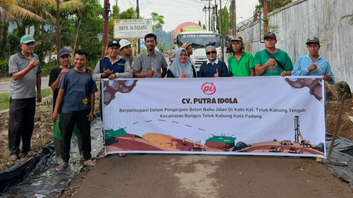 Direktur CV Putra Idola, Yarsina Devi, foto bersama warga saat pembangunan beton bahu jalan di RW 02, Kelurahan Teluk Kabung Tengah, Padang.