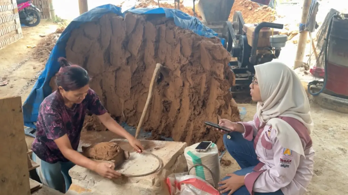 Kak Ani mengerjakan proses produksi batu bata secara tradisional di UMKM Berkah Bersama, Nagari Koto Baru, Kecamatan Baso, Kabupaten Agam. (Dok Mhs KKN UNP 2026)