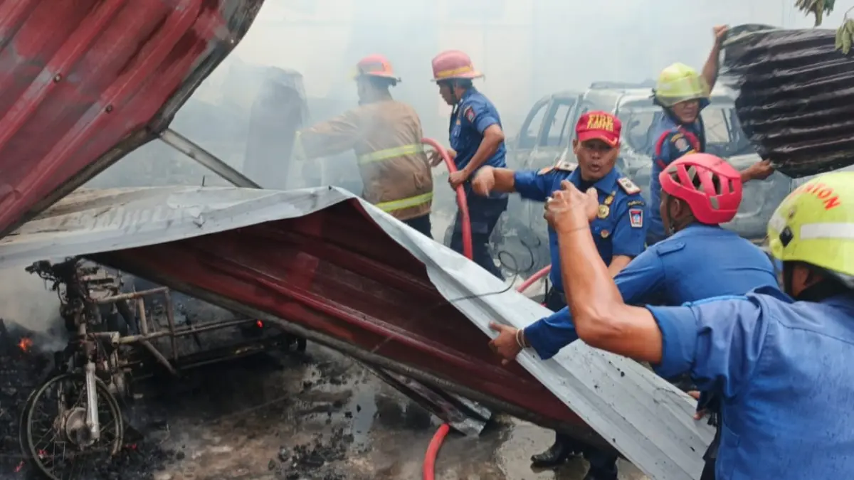Petugas Dinas Damkar Kota Padang berupaya memadamkan api yang menghanguskan rumah dan toko di Kelurahan Dadok Tunggul Hitam, Kecamatan Koto Tangah, Kota Padang, Senin (3/8/2026). 