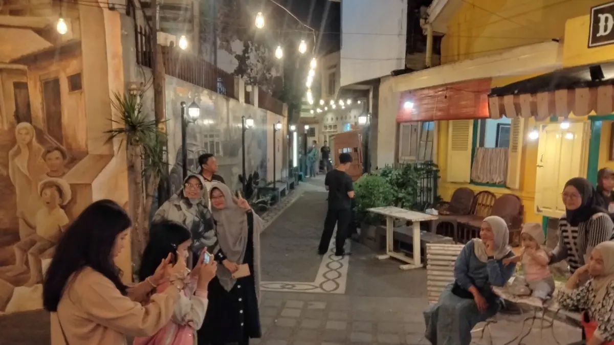 Suasana malam di Kajoetangan Heritage, Malang, dipenuhi wisatawan yang menikmati lorong kawasan bersejarah dengan deretan bangunan lama, mural, dan kedai warga. (Dok. Endang Pribadi)