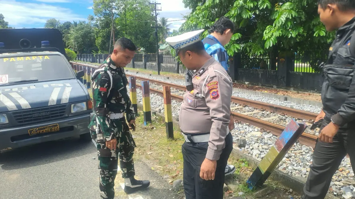Petugas kepolisian melakukan olah TKP di perlintasan kereta api depan bundaran UNP atau depan Yonif 133/YS, Selasa (4/8/2026).