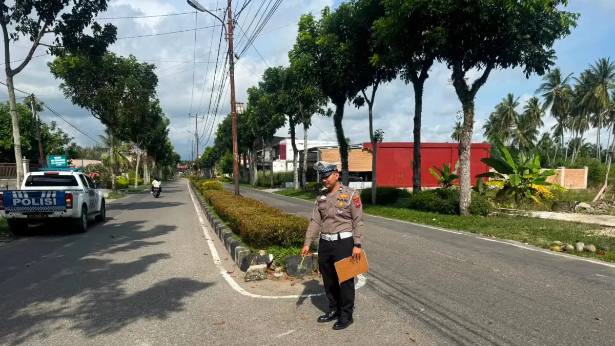 Personel Satlantas Polres Agam melakukan olah tempat kejadian perkara (TKP) kecelakaan di Jalan Sultan Syahrir, dekat Samsat Lubuk Basung, Kabupaten Agam, Minggu (9/8). (SATLANTAS POLRES AGAM)