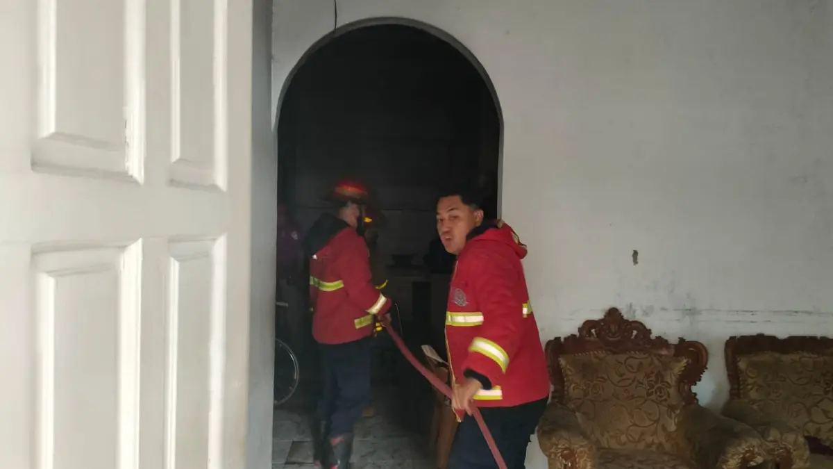 Petugas Damkar Padang sedang memadamkan api di dalam kamar rumah milik Yuniar di Surau Gadang, Nanggalo, Padang, Kamis (13/8/2026).