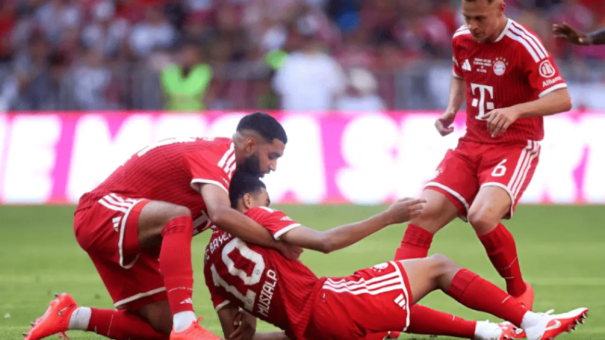 Ismael Saibari membantu Jamal Musiala yang kehilangan keseimbangan sebelum kolaps di lapangan saat Bayern Munich menghadapi RB Leipzig dalam laga pramusim di Allianz Arena. (Foto: X @iMiaSanMia)