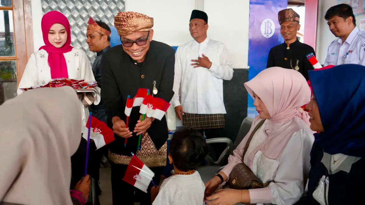 Kepala KAI Divre II Sumbar Lutfi Wijaya membagikan bendera kecil Merah Putih kepada pelanggan dalam rangka menyemarakkan HUT ke-81 Kemerdekaan RI.