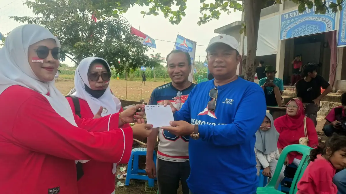 Sekretaris DPC Partai Demokrat Pasbar Endra Yama Putra menyerahkan hadiah kepada pemenang lomba tarik tambang dewasa di Perumahan Royal Pasaman, Kecamatan Pasaman, Minggu (23/8/2026).