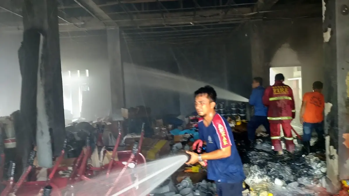 Petugas Damkar Padangpariaman memadamkan kebakaran yang melahap toko bangunan di Batang Anai, Senin (24/8/2026). 