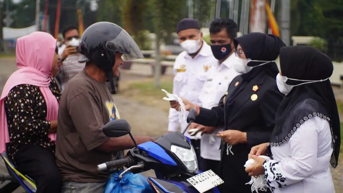Wakil Bupati Dharmasraya Leli Arni bersama jajaran Pemkab Dharmasraya membagikan masker kepada pengguna jalan di Pulau Punjung, Rabu (26/8/2026).