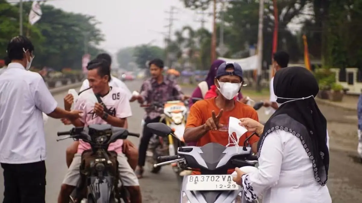 Petugas membagikan masker kepada pengendara yang melintas di kawasan Pulau Punjung, Dharmasraya, sebagai antisipasi dampak kabut asap, Kamis (3/9/2026).