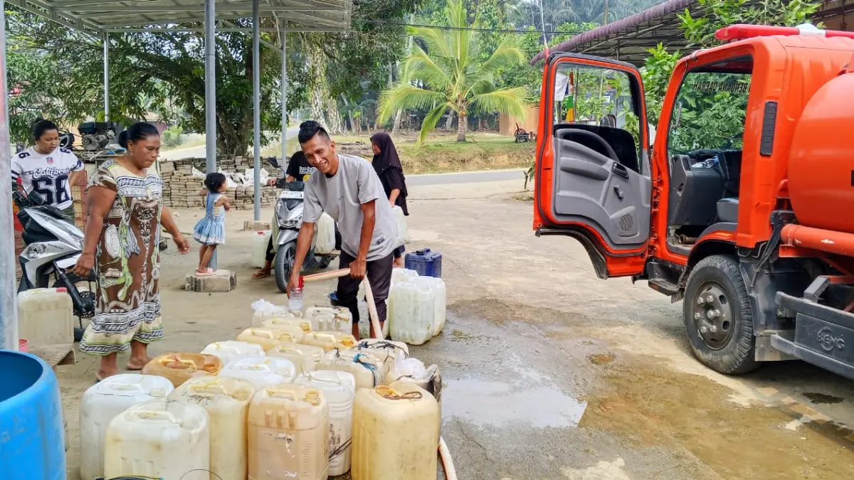 Warga mengisi ember dan jeriken dengan air bersih dari mobil tangki bantuan BPBD Dharmasraya untuk memenuhi kebutuhan sehari-hari di tengah kemarau.