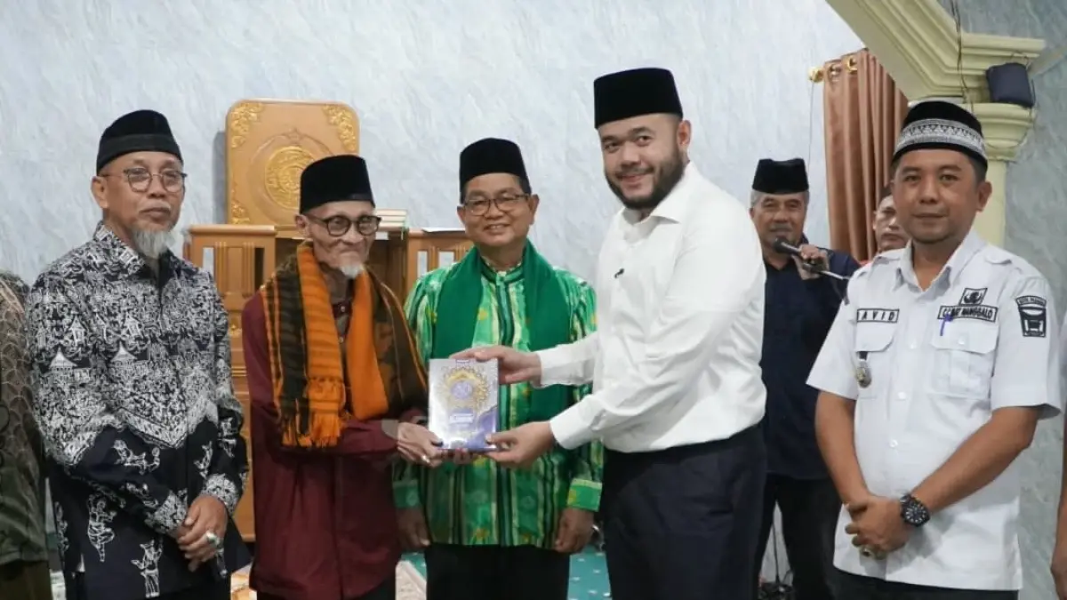 Penyerahan bantuan Al-Qur’an Gebu Minang Jabar dari Wako Fadly Amran kepada pengurus Masjid Al Munawwarah Padang, Buya Masoed Abidin.(Foto: Diskominfo)