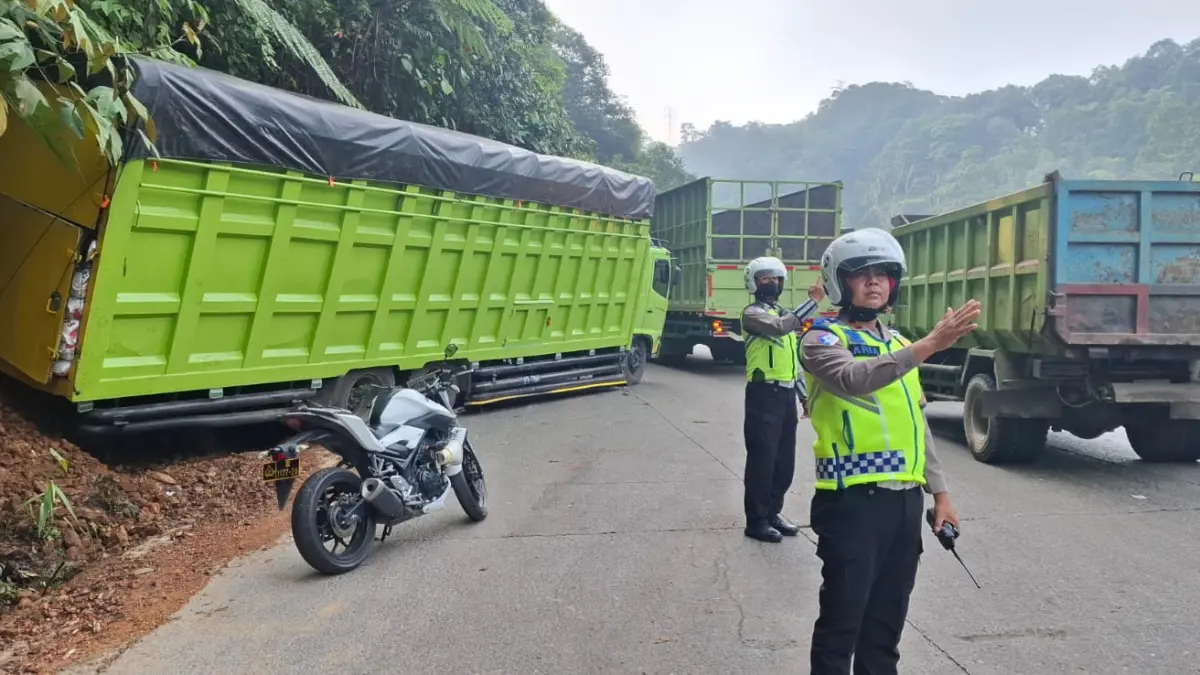 Petugas Satlantas Polresta Padang mengatur arus kendaraan di kawasan Kelok Tunggua, Sitinjau Lauik, Padang, Jumat (18/9/2026). Langkah ini diambil setelah sebuah truk mengalami rem blong hingga menabrak tebing dan satu unit truk lainnya rusak di tengah jalan. (Foto: Satlantas Polresta Padang)