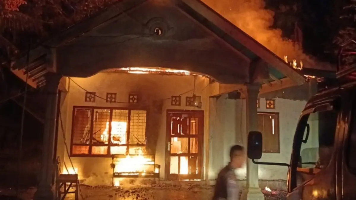 Petugas Damkar Padangpariaman berupaya memadamkan kobaran api yang menghanguskan rumah warga di VII Koto Sungai Sarik, Minggu (20/9/2026) malam.