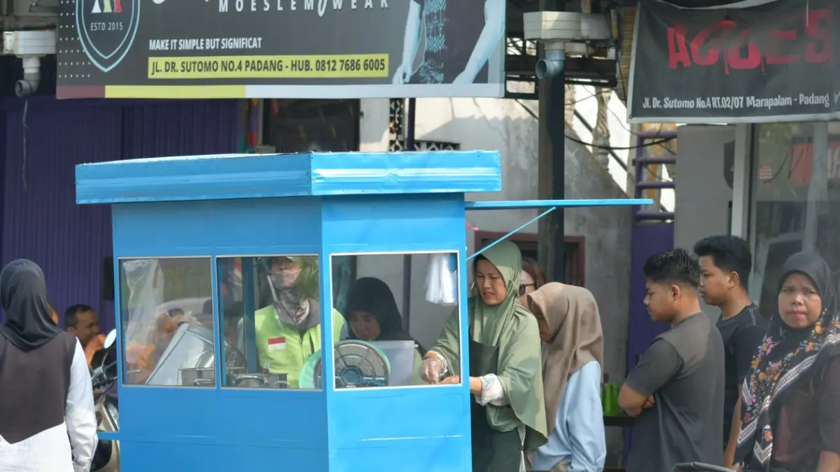 Rika Hijra melayani pelanggan di usaha sarapannya di Jalan Sutomo, Kubu Marapalam, Padang Timur, Kota Padang.