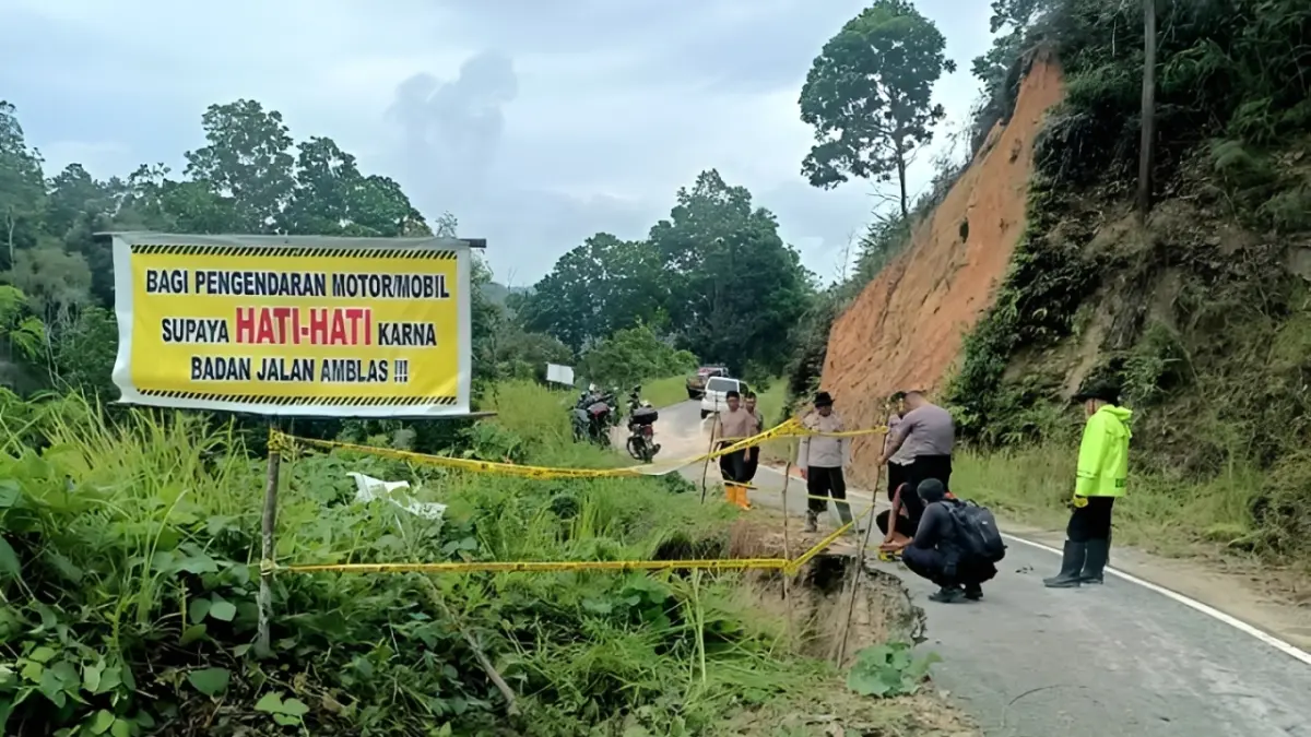 Petugas membersihkan tanaman liar dan material di jalan penghubung Nagari Kuncir dan Nagari Paninjauan untuk mengurangi risiko kecelakaan.