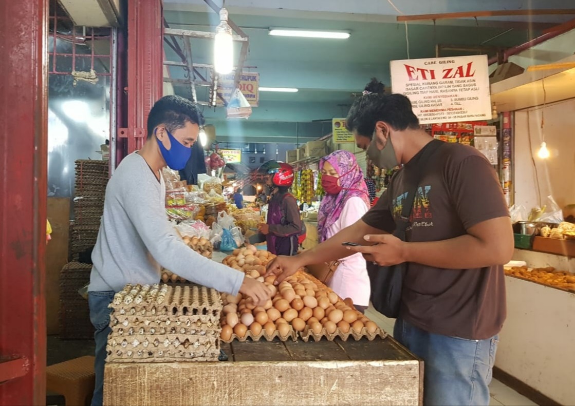Salah seorang pedagang telur di Pasar Raya Padang sedang melayani pembeli, kemarin. (Randi - Padek)