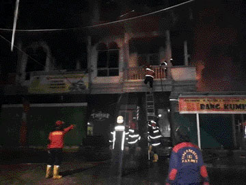 Petugas Damkar Kota Padang memadamkan api yang menghanguskan ruko di Jalan Ujunggurun, kemarin. (IST)