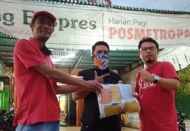 Staf Humas BLK Padang Dhani (tengah)  menyerahkan bantuan masker di depan Kantor Perwakilan Padang Ekspres, Jalan Juanda Padang. (foto: ist)