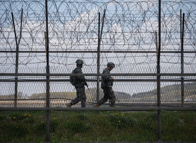 Dua tentara Korea Selatan berpatroli di zona demiliterisasi (DMZ). Foto diambil pada 23 April. Pada Minggu (3/5), perbatasan Korsel dan Korut memanas (Ed JONES / AFP)