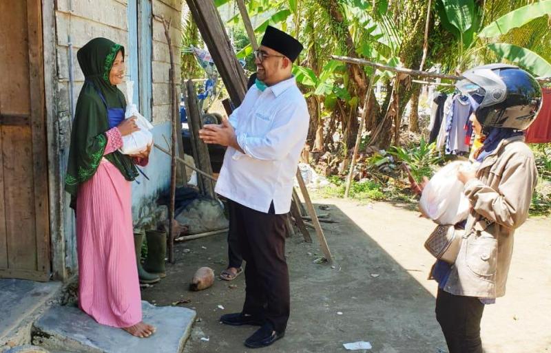 Bendahara Partai Golkar sekaligus Ketua Pemuda Pancasila Sumbar, Ercik Hariyona mengantarkan bantuan ke rumah warga terdampak di Pasbar. (Foto: ST)
