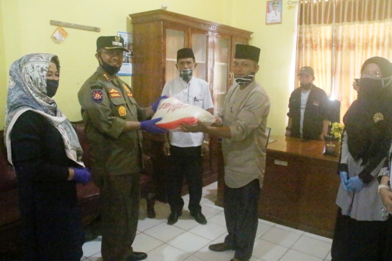 Bupati Solok Gusmal menyerahkan bantuan beras kepada masyarakat Kotosani. (Foto: Humaskab)