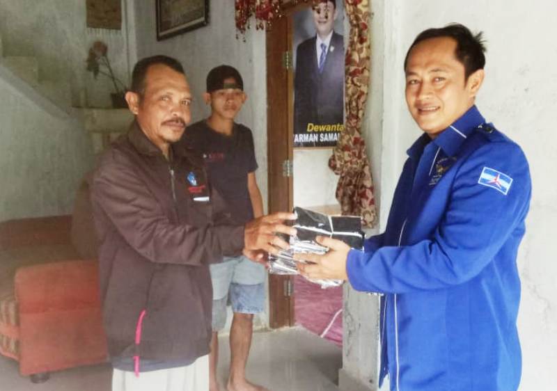 Kader Partai Demokrat di Kepulauan Mentawai Juniarman Samaloisa membagikan masker untuk masyarakat. (Foto: Arif)