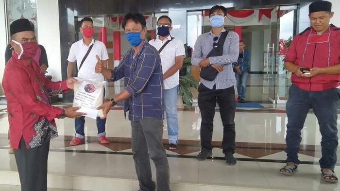 Ketua DPRD Dharmasraya Pariyanto menyerahkan paket sembako di DPRD Dharmasraya. (Foto: IST)