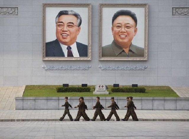 Foto besar Kim Il-sung dan Kim Jong-il di Lapangan Kim Il-sung di Pyongyang. Kabarnya, kedua foto tersebut dicopot karena akan direnovasi. Namun, isu kematian Kim Jong Un malah kembali mencuat (Express)